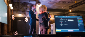 Two people talking on microphones at an event.
